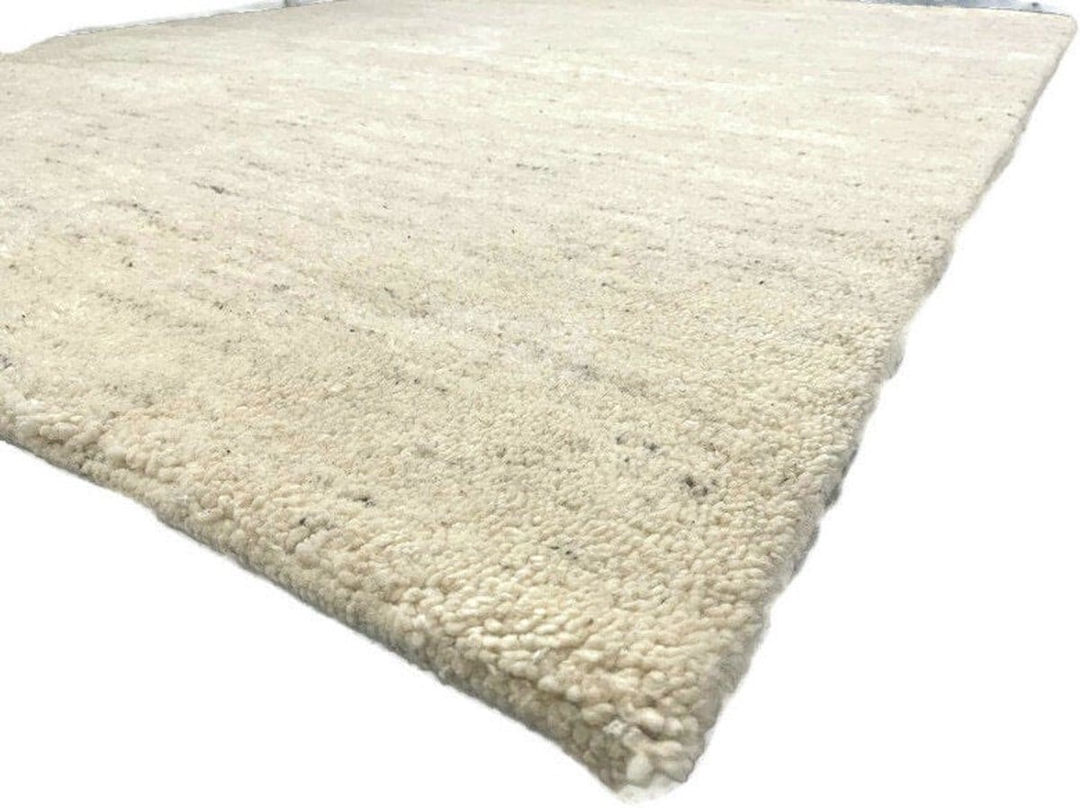 Een beige, rechthoekige, ruige Houseify Handmade | Berber Vloerkleed | Gemêleerde wit met een zachte textuur, gefotografeerd vanuit een laag standpunt.