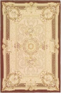 Een beige en bruin vloerkleed met een sierlijk dessin.