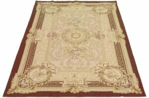 Beschrijving: Een vloerkleed met een ornamenteel ontwerp in beige en bruin.