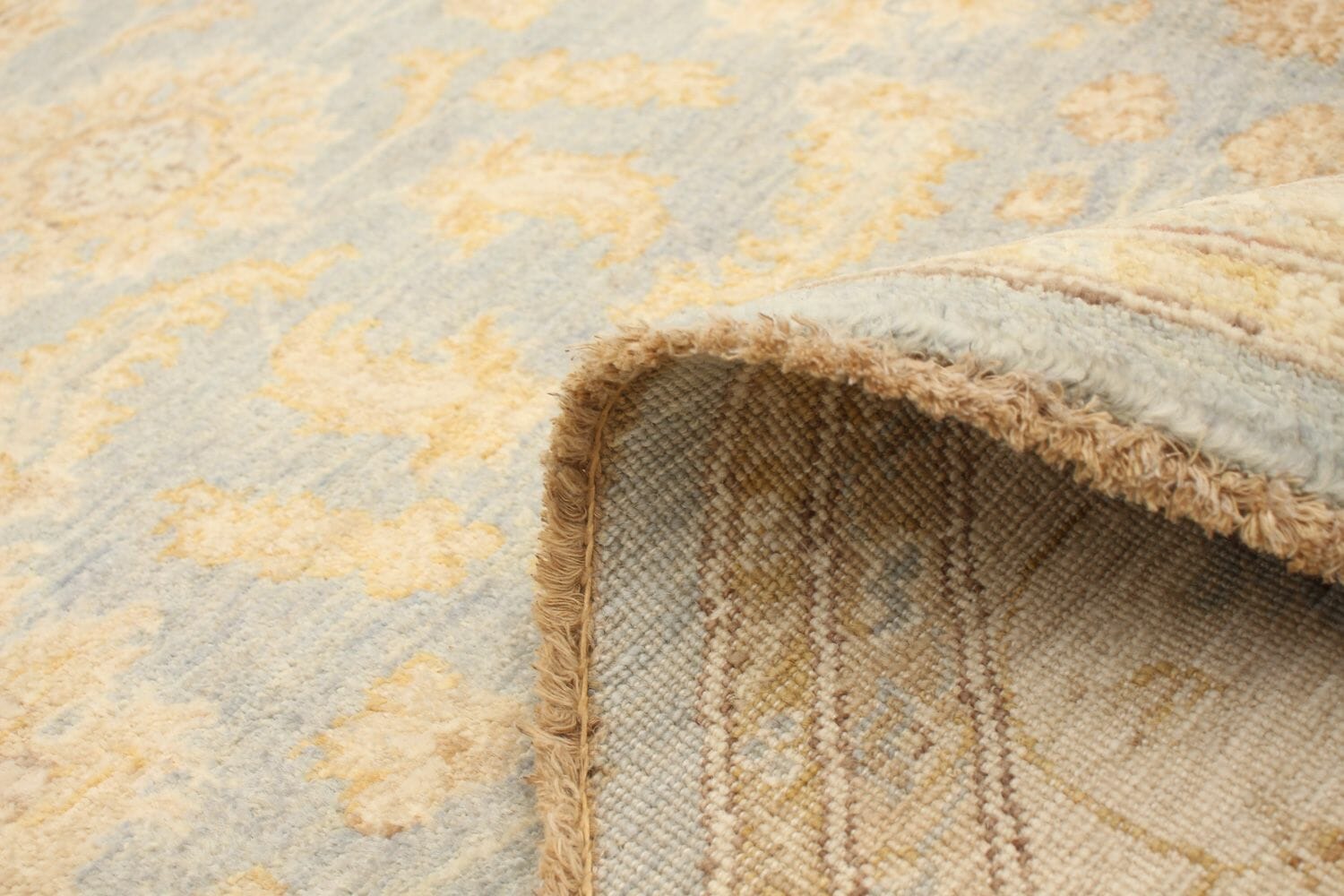 Een vloerkleed met een ornamenteel patroon in blauw en beige.