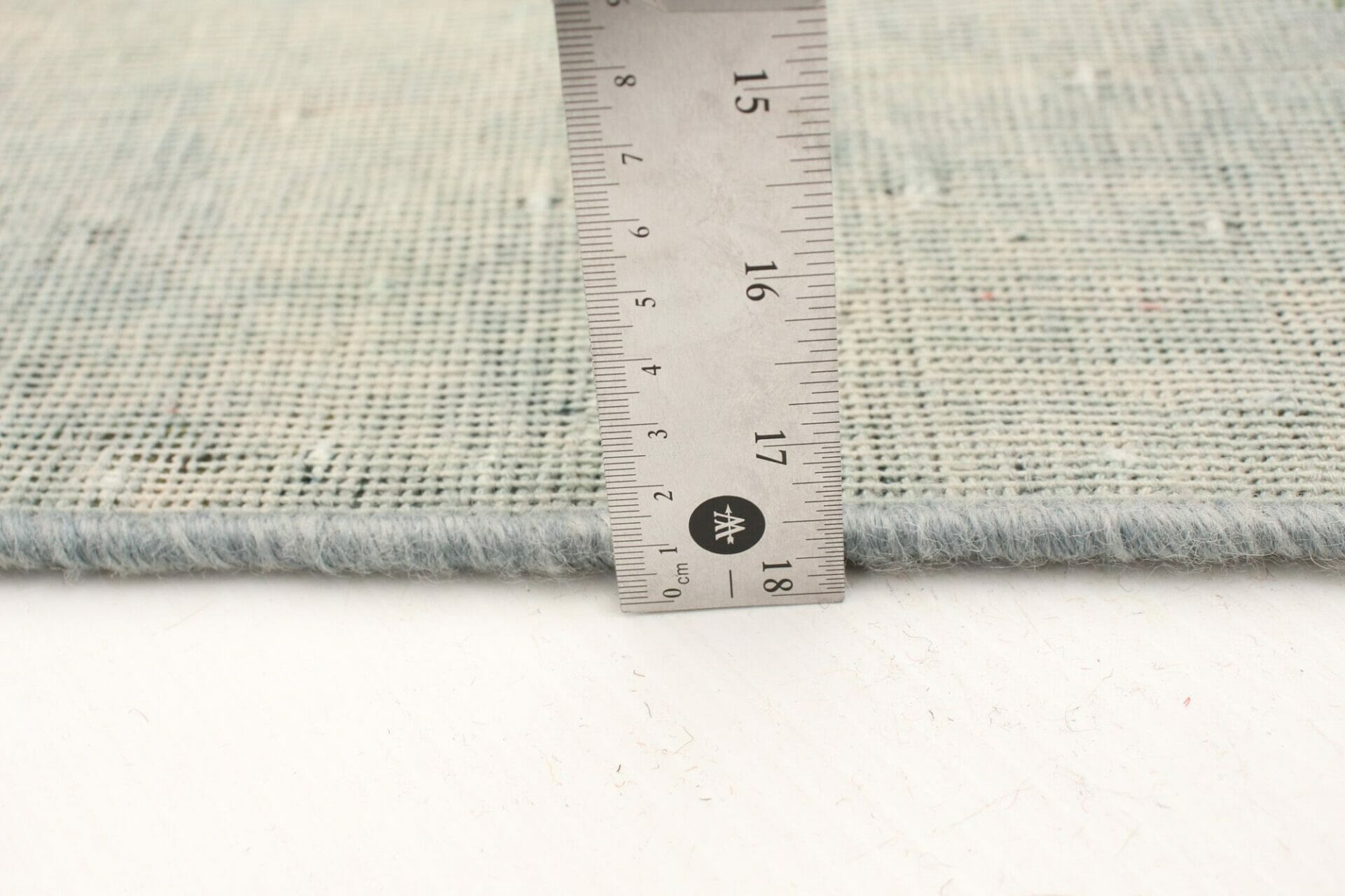 Een vloerkleedliniaal wordt gebruikt om de lengte van een vloerkleed te meten.
