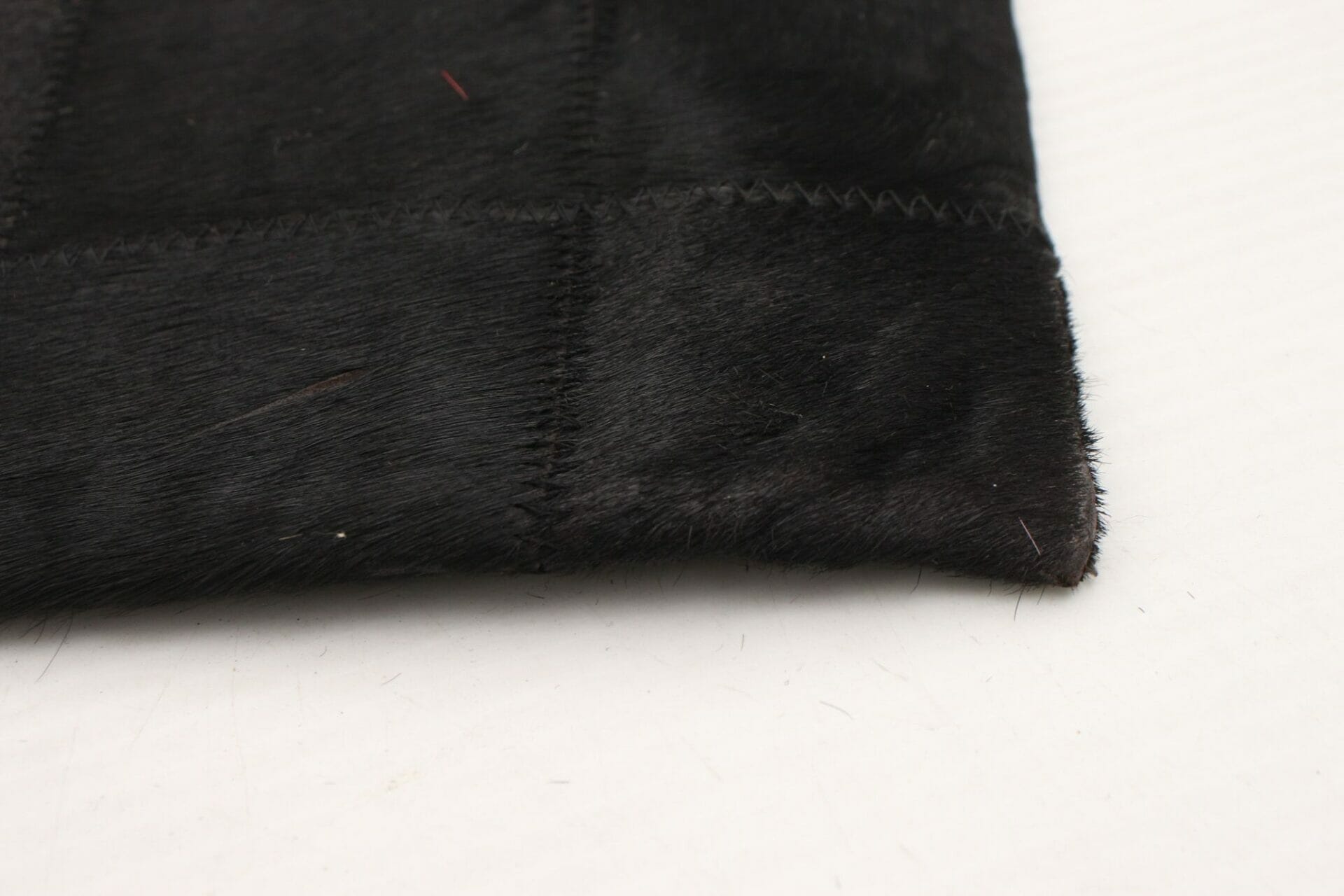 Een close up van een stuk zwart vloerkleed bont.