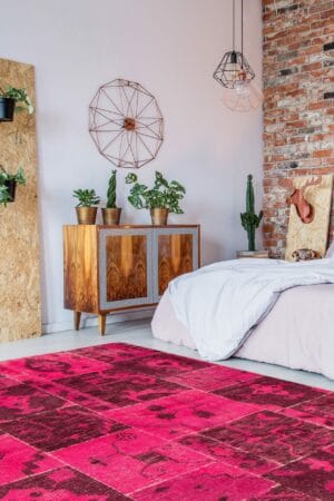 Een roze tapijt in een slaapkamer met een houten muur.