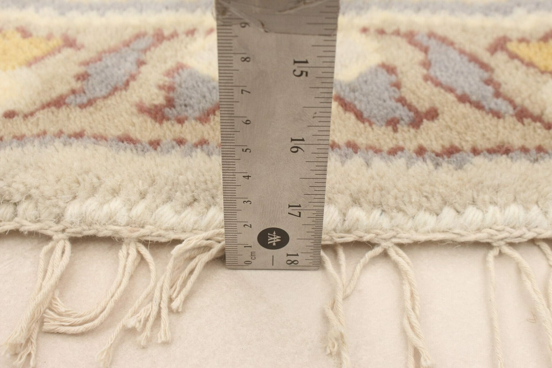 Een vloerkleed wordt gemeten met behulp van een liiaal.