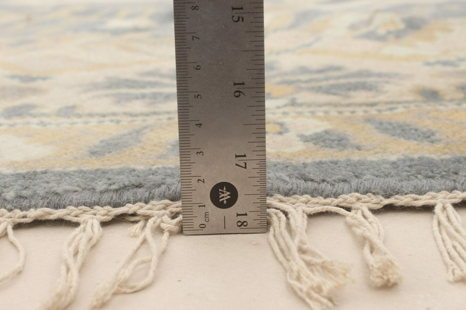 Een vloerkleed wordt gemeten met behulp van een liiaal.
