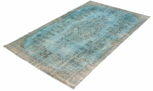 Een blauw en goudkleurig tapijt op een wit vloerkleed.