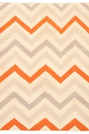 Beschrijving: Een oranje en grijs chevron vloerkleed op een witte achtergrond.