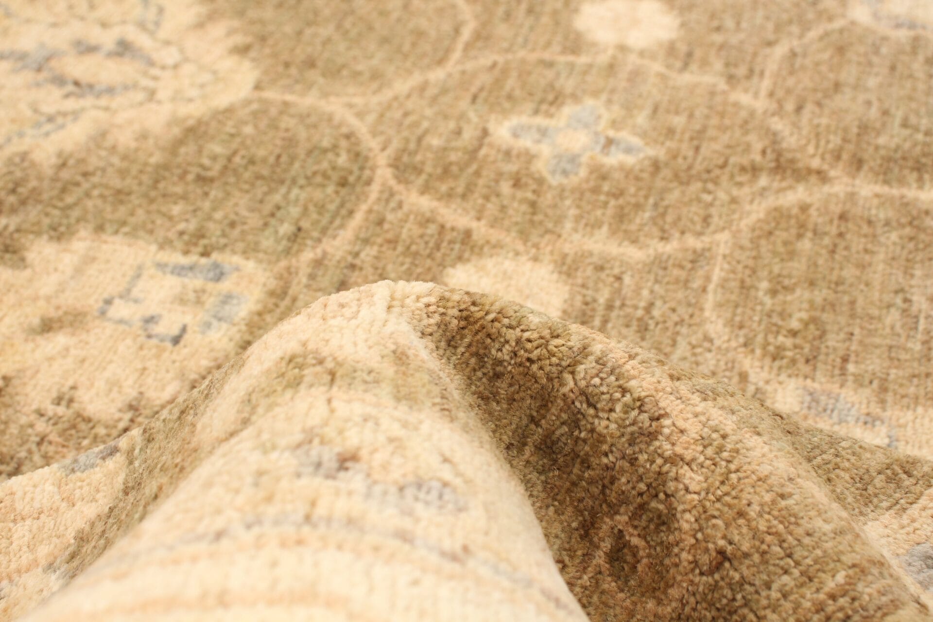 Beschrijving: Een close-up van een tapijt, beige en bruin gekleurd.