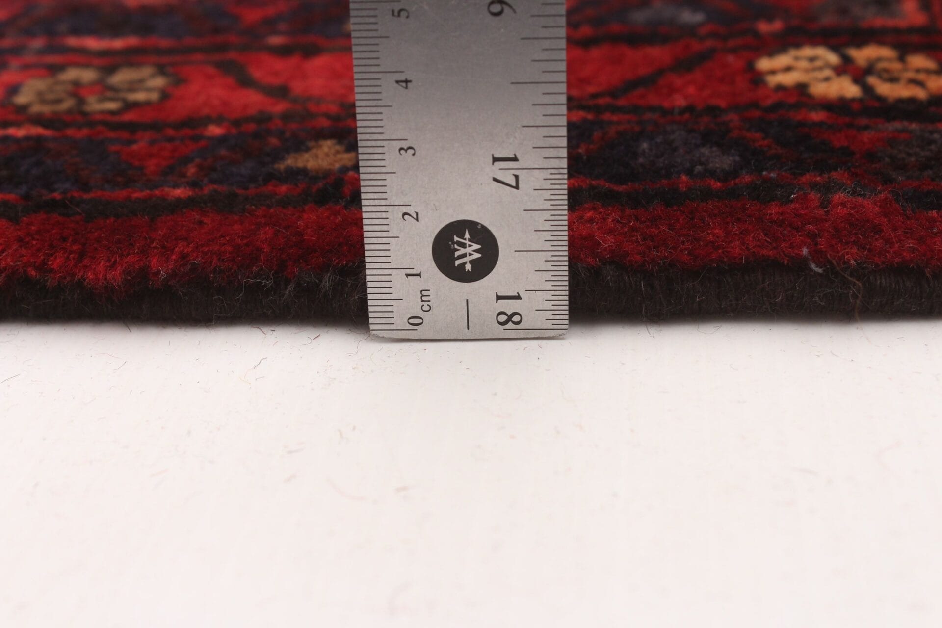 Een vloerkleed wordt onder een liniaal geplaatst.