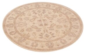 Een rond vloerkleed met beige en beige bloemmotieven.