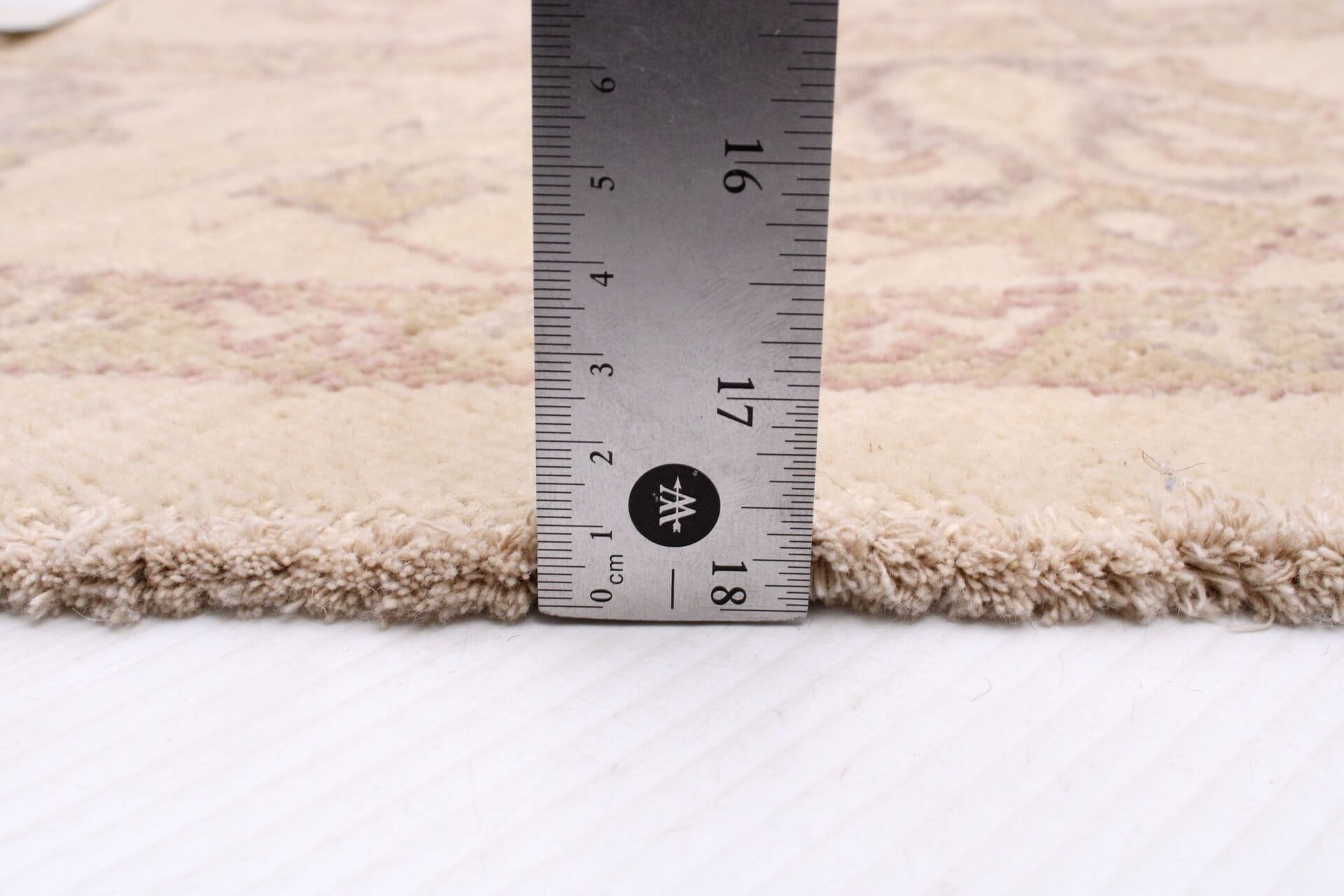 Voor het meten van de lengte van een vloerkleed wordt een liniaal gebruikt.