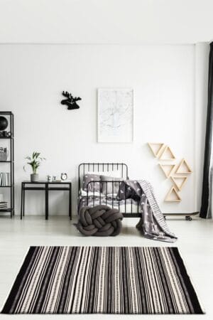 Een zwart-wit gestreept vloerkleed in een slaapkamer.