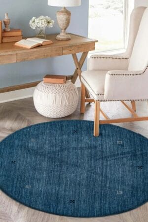 Een blauw vloerkleed in een woonkamer met een stoel.