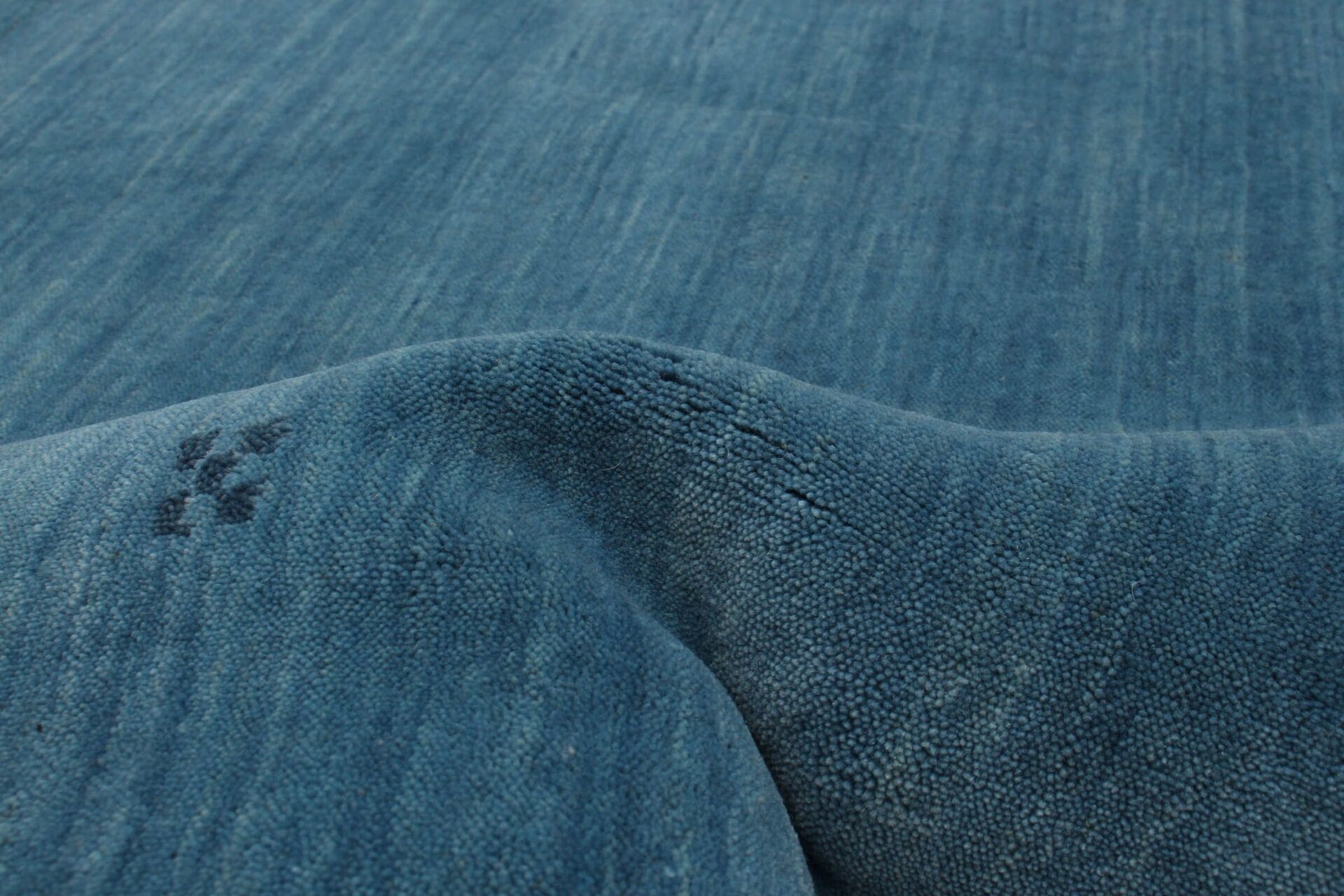 Een close-up afbeelding van een blauw vloerkleed.
