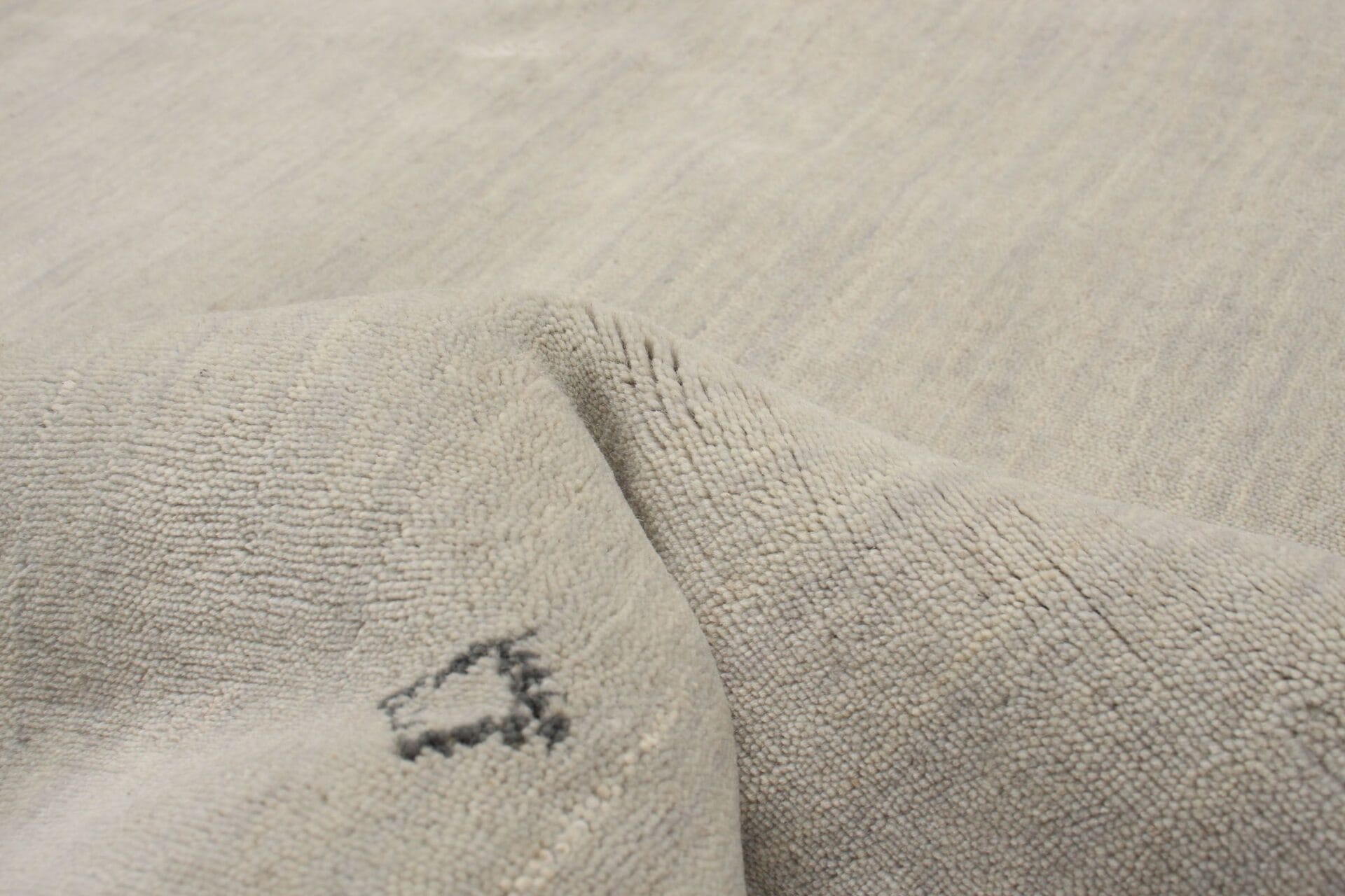 Een close-up afbeelding van een grijs vloerkleed.