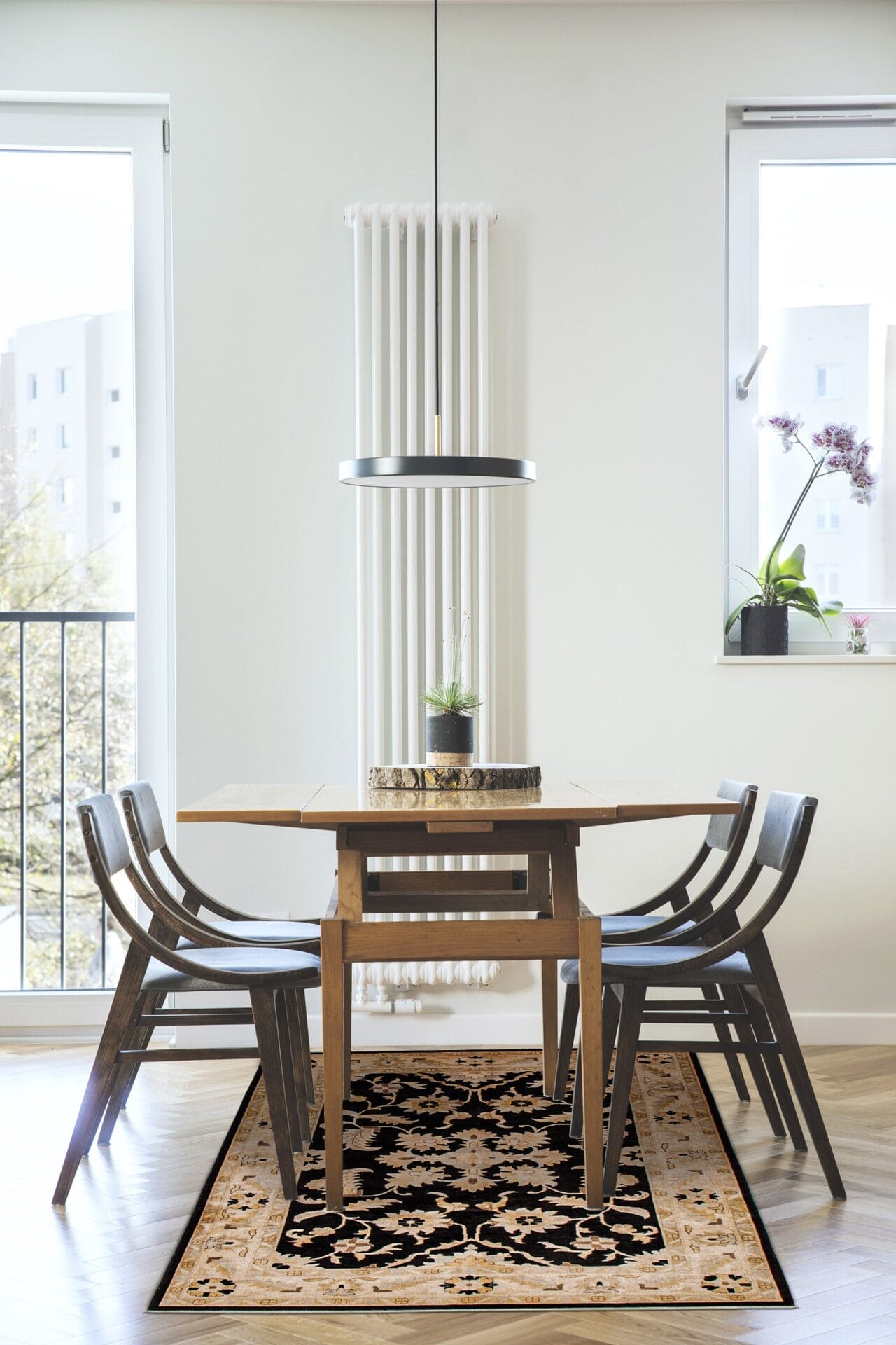 Een eetkamer met een zwart tapijt en stoelen.