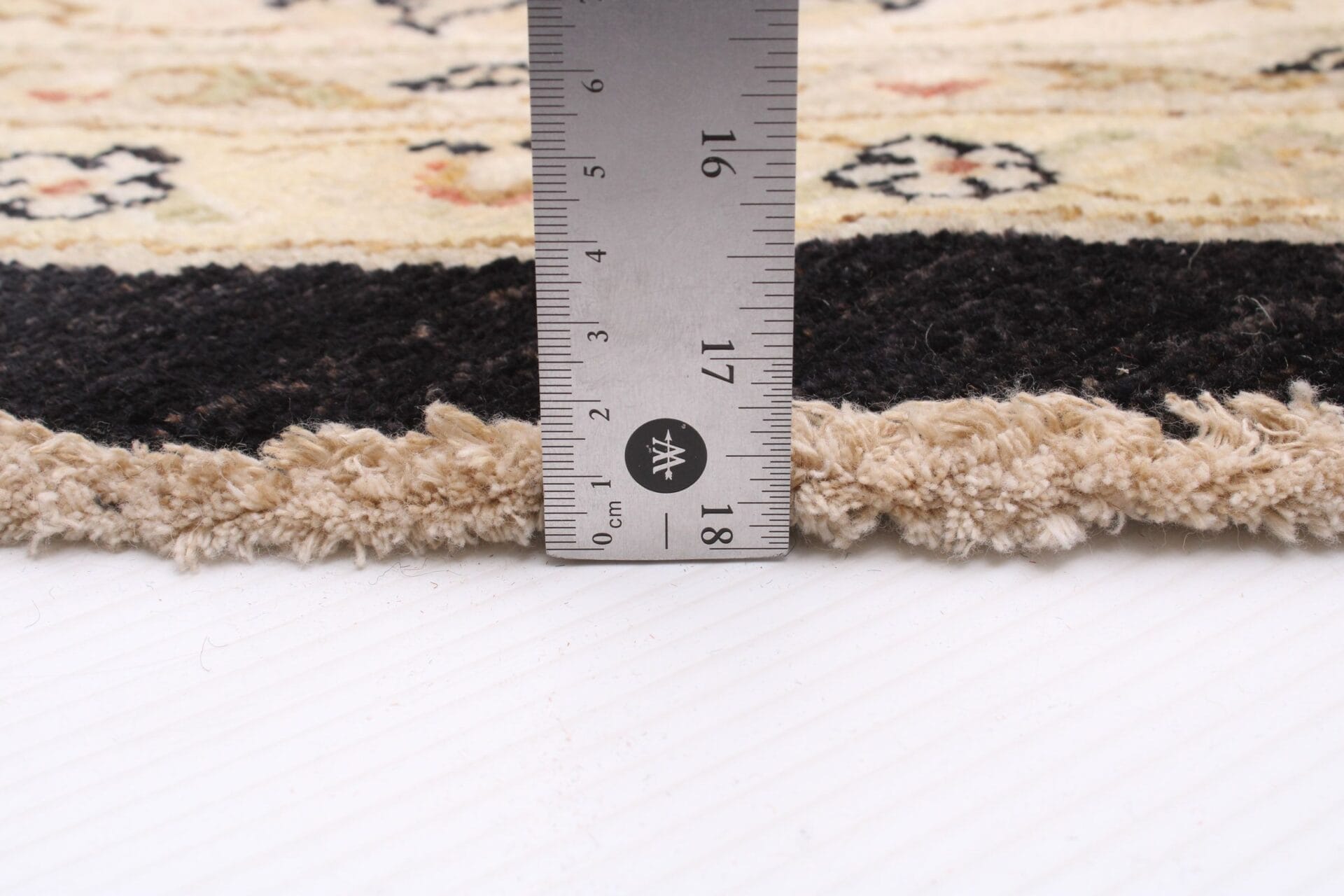 Beschrijving: Een tapijt met een liniaal erbovenop.
