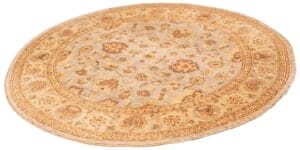 Een beige en bruin rond vloerkleed met bloemmotieven.