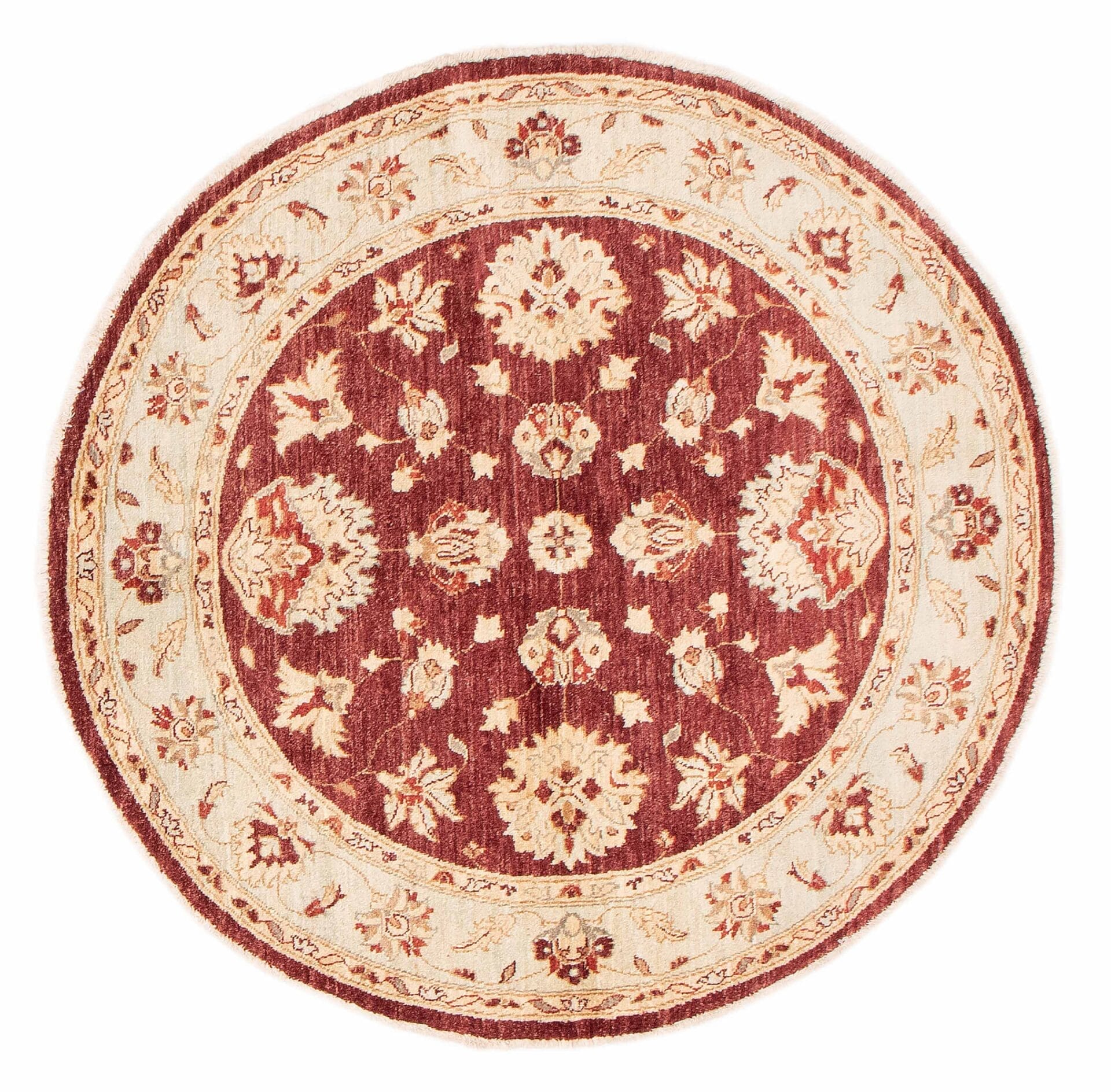 Beschrijving: Een rond tapijt met een rood en beige bloemmotief.