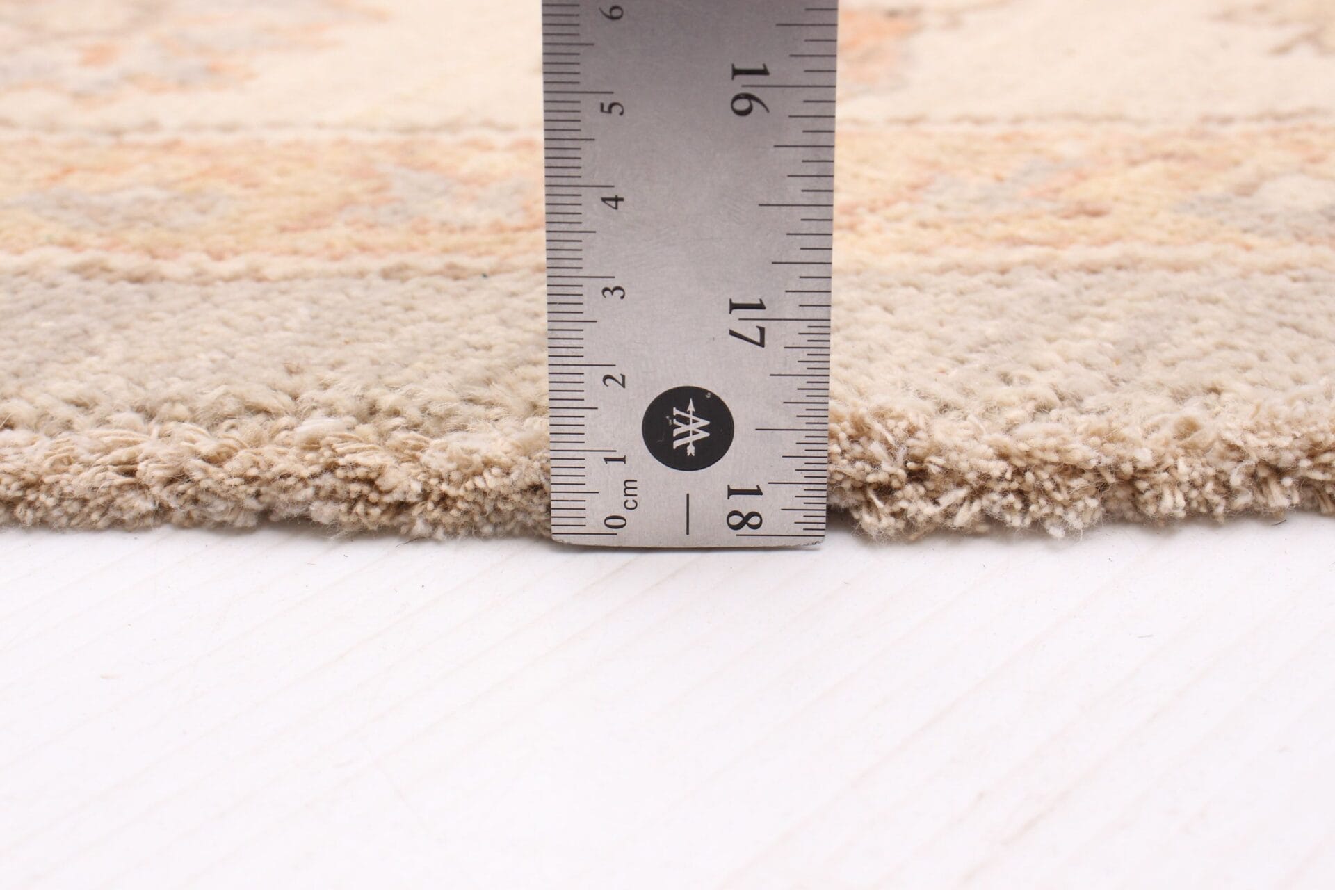 Voor het meten van de lengte van een vloerkleed wordt een liniaal gebruikt.
