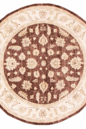 Een bruin en beige rond tapijt/vloerkleed met een sierlijk dessin.