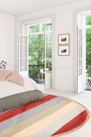 Een slaapkamer met een kleurrijk gestreept vloerkleed.