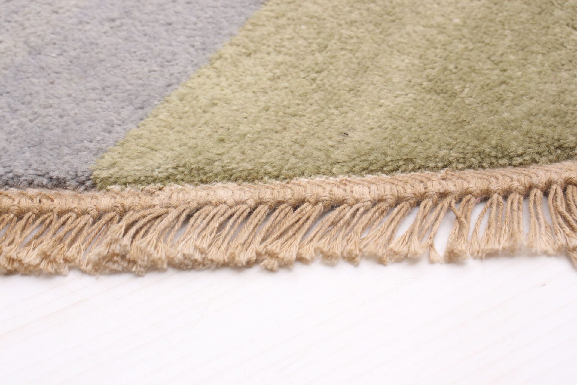 Een close-up van een tapijt met franjes erop.