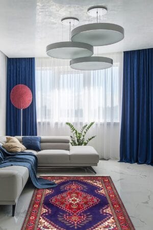 Een woonkamer met blauwe gordijnen en een vloerkleed.