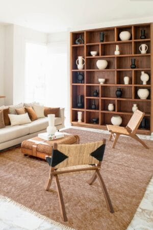 Een woonkamer met bruin meubilair en een houten boekenkast.