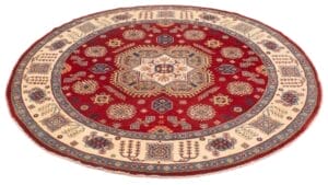 Een rond vloerkleed met rode en blauwe motieven.