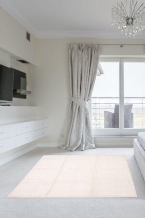 Een witte slaapkamer met een tv en een vloerkleed.