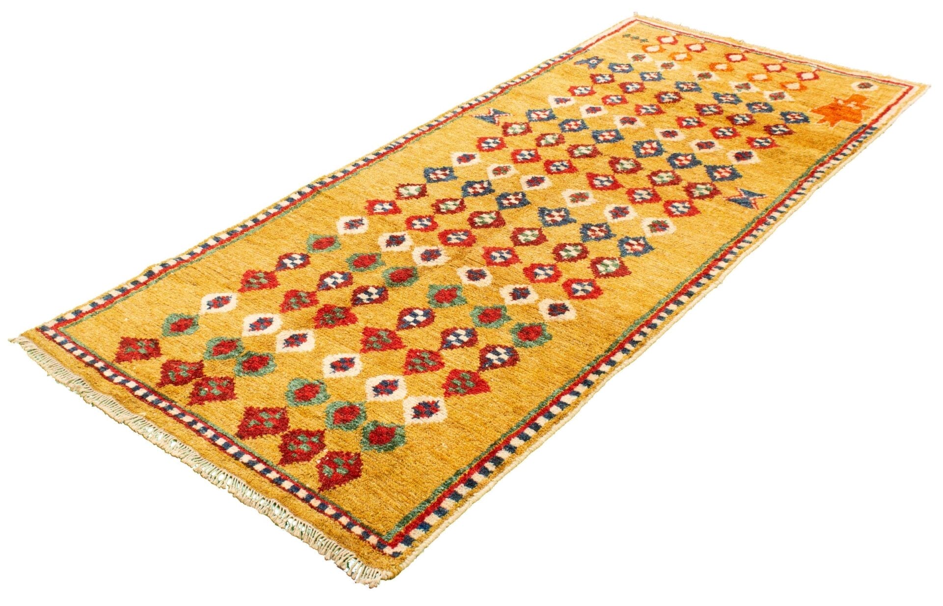 Geel tapijt met veelkleurige ruit- en bloemmotieven, franjeranden en een decoratieve rand.