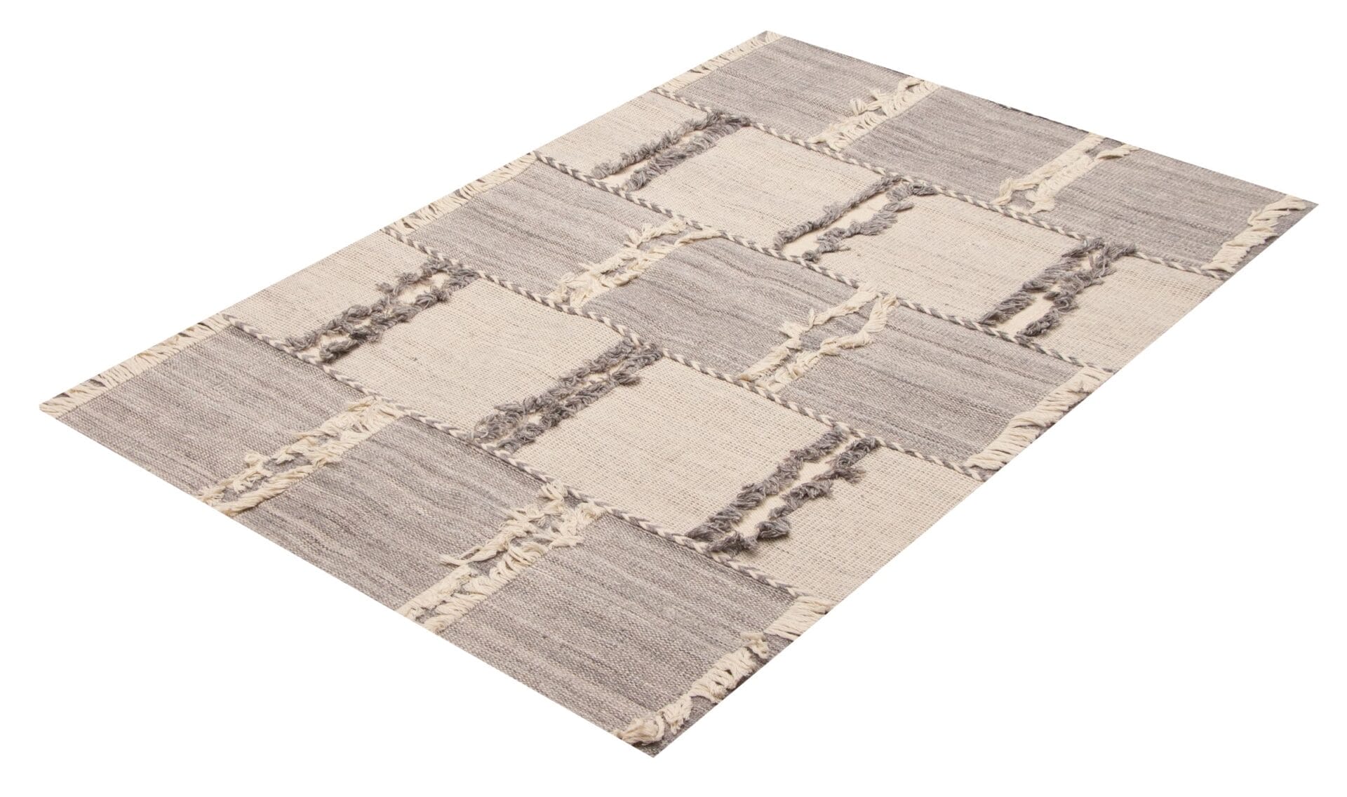 Een rechthoekig vloerkleed met een patroon van in elkaar grijpende beige en grijze blokken. Het vloerkleed heeft aan de korte zijden franjes aan de randen.
