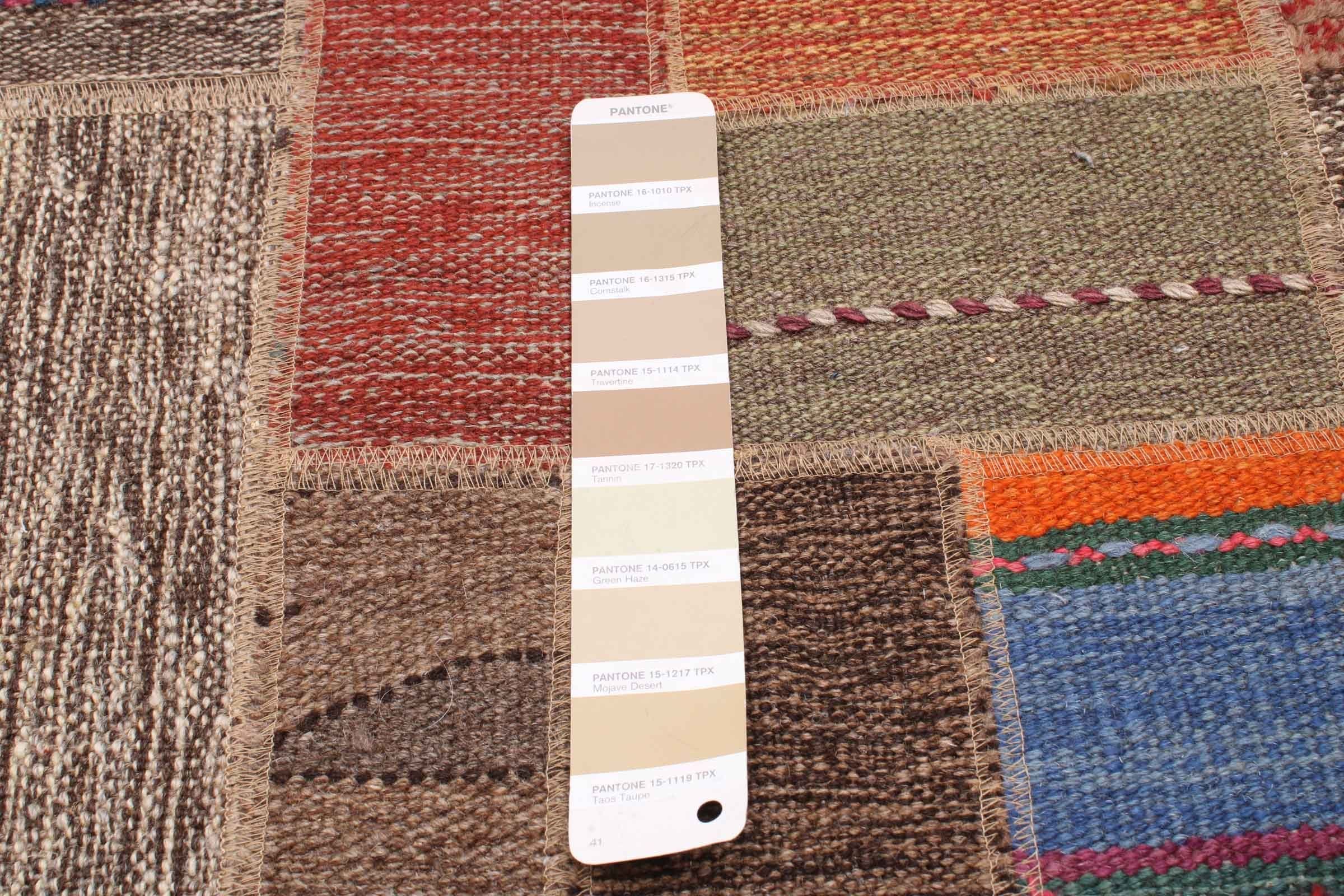 Een Pantone-kleurstaal met verschillende tinten beige en bruin is op een gestructureerde, veelkleurige tapijtachtergrond geplaatst.