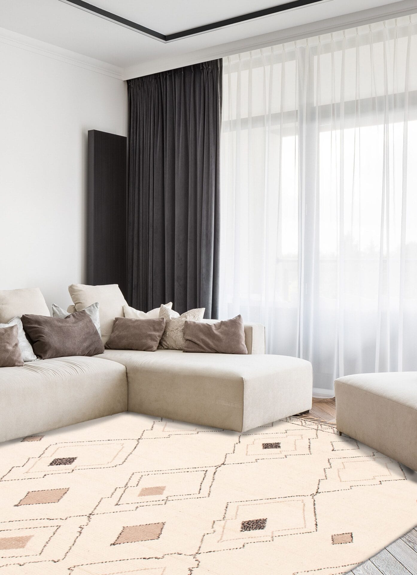 Een moderne woonkamer is voorzien van een beige sofa, bruine en beige kussens, een vloerkleed met lichte patronen, donkere gordijnen en doorschijnende witte gordijnen voor kamerhoge ramen.