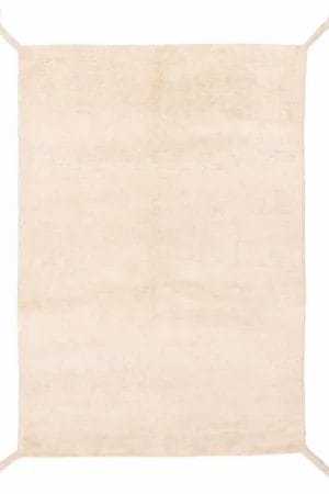 Een rechthoekig Indiase Tanger handgeknoopte wollen vloerkleed in effen beige, 140 x 196 cm, met licht rafelige hoeken en minimale textuur.