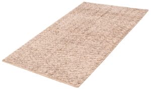 Een rechthoekig beige shaggy vloerkleed op een witte achtergrond.