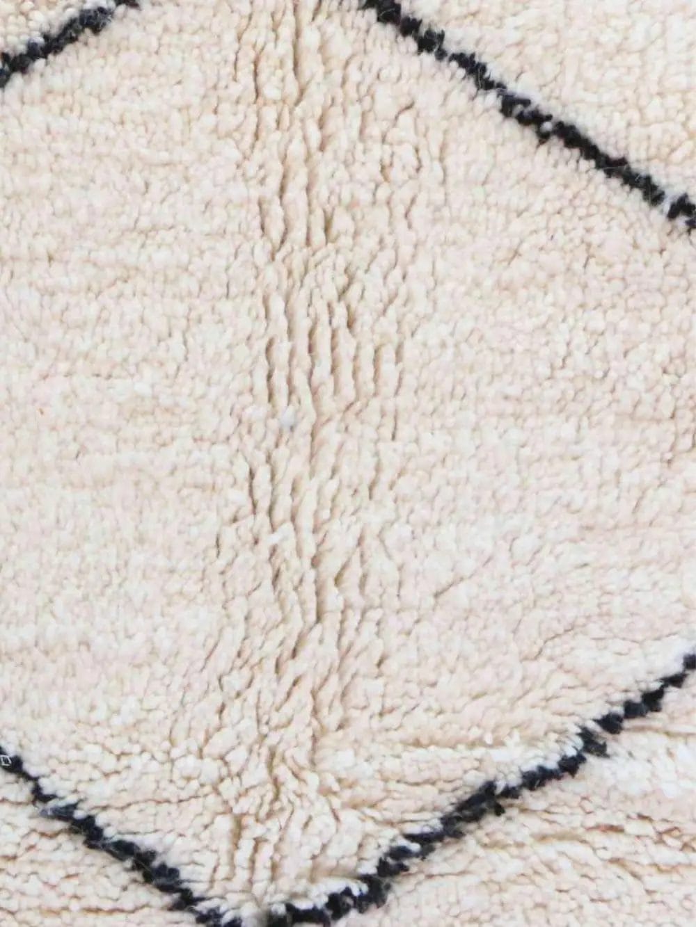 Close-up van een beige structuurstof met een ruitpatroon omlijnd door zwarte lijnen.
