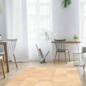 Een woonkamer met een houten vloer en een beige vloerkleed. (Trefwoorden: tapijt)