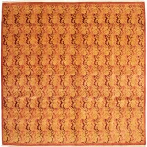 Beschrijving: Een oranje en bruin tapijt met een bloemenpatroon.
