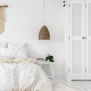 Een witte slaapkamer met een rond vloerkleed.