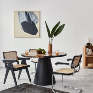 Een moderne eetkamer met een zwarte tafel en stoelen.