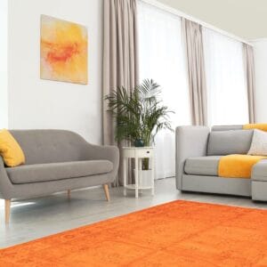 Een oranje vloerkleed in een woonkamer.