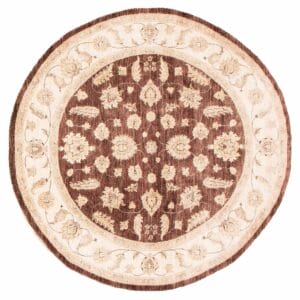 Een bruin en beige rond tapijt/vloerkleed met een sierlijk dessin.