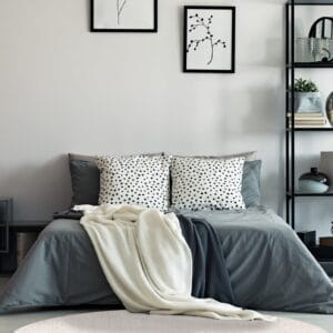 Een slaapkamer met een wit bed en een rond tapijt.