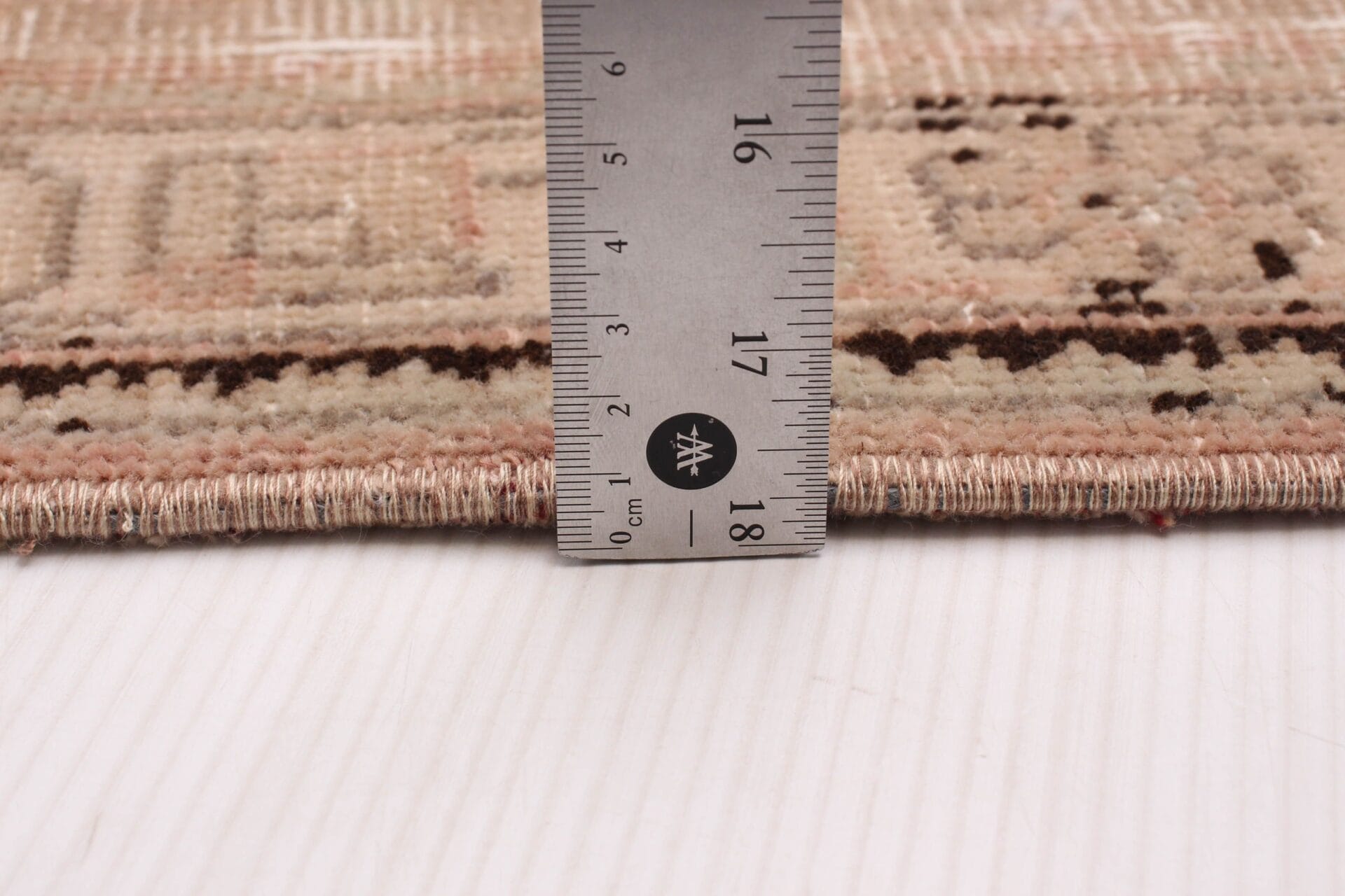Voor het meten van de maat van een vloerkleed wordt een liniaal gebruikt.