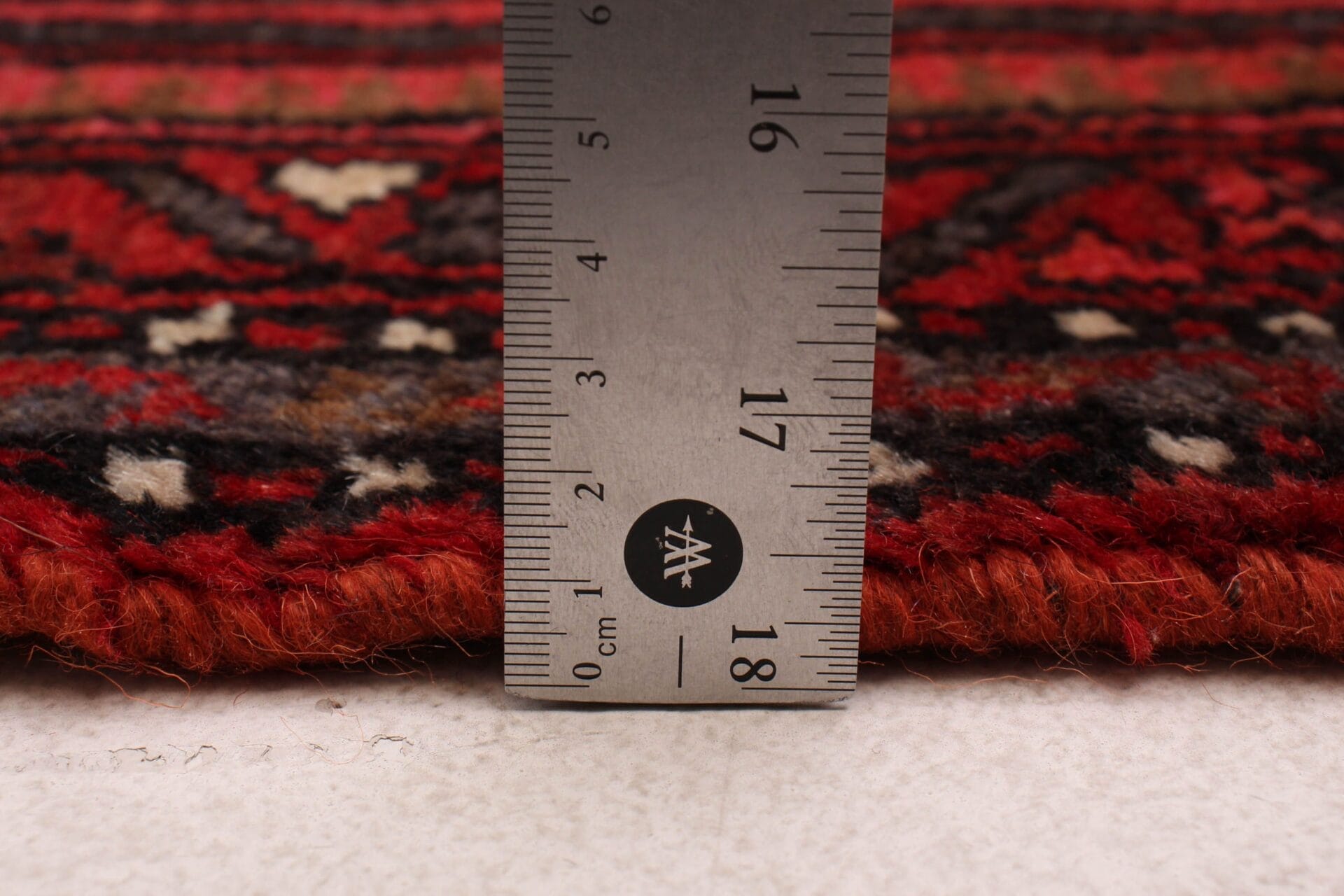 Om de lengte van een tapijt te meten, wordt een liniaal gebruikt.