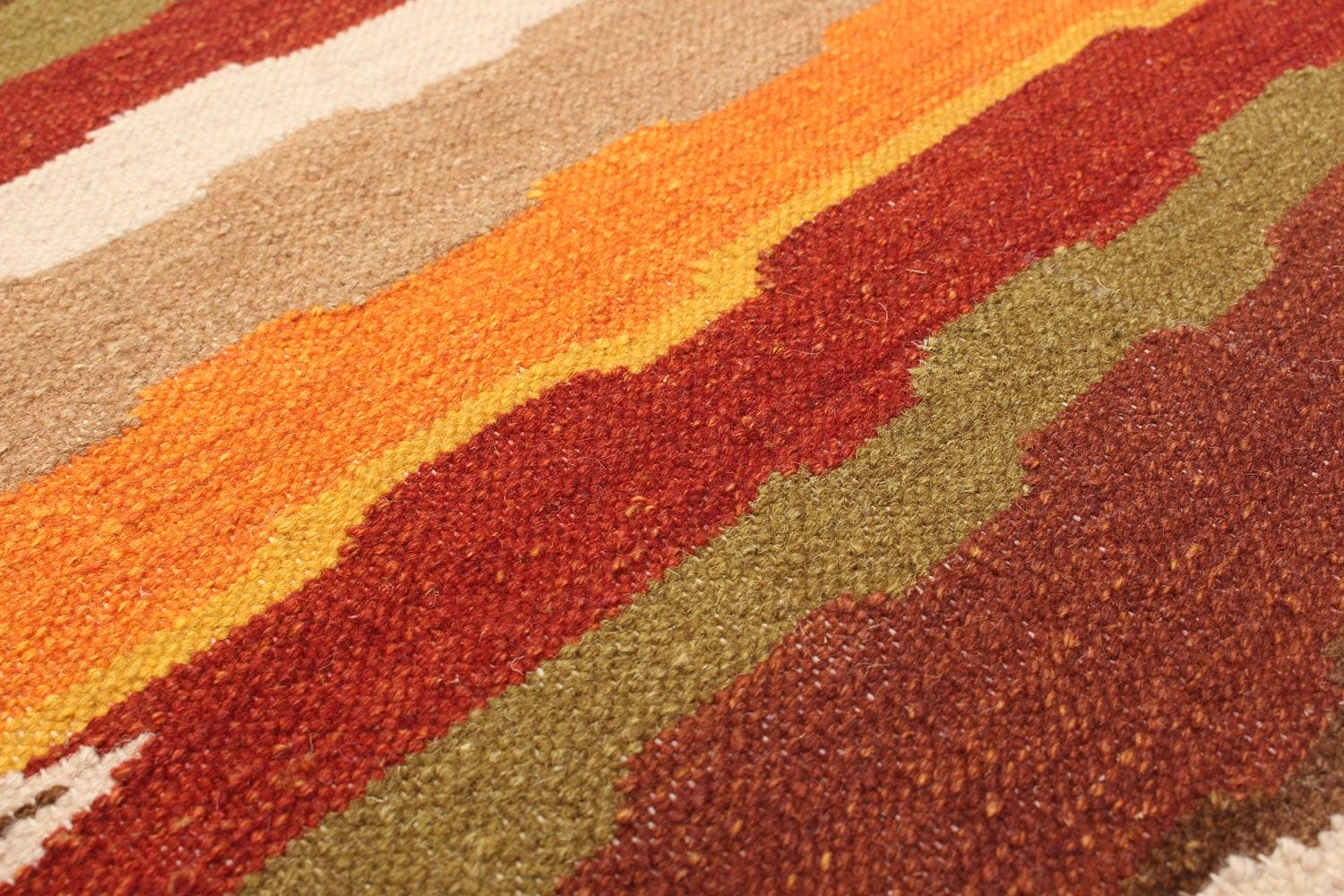 Close-up van een geweven stof met horizontale strepen in de tinten rood, oranje, beige en groen.