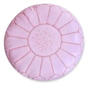 Een Roze hoes van Marokkaanse leren poef, met een rond ontwerp met gesegmenteerde delen en geborduurde bloempatronen in het midden, is perfect als aanvulling op elk vloerkleed of tapijt.