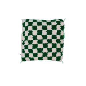 Een vierkant kussen met groen-wit schaakbordpatroon en een zachte textuur.